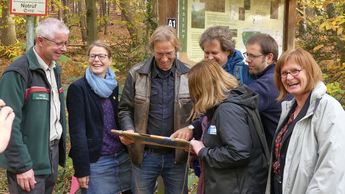 Mehrere Menschen stehen um eine Karte herum und zeigen darauf