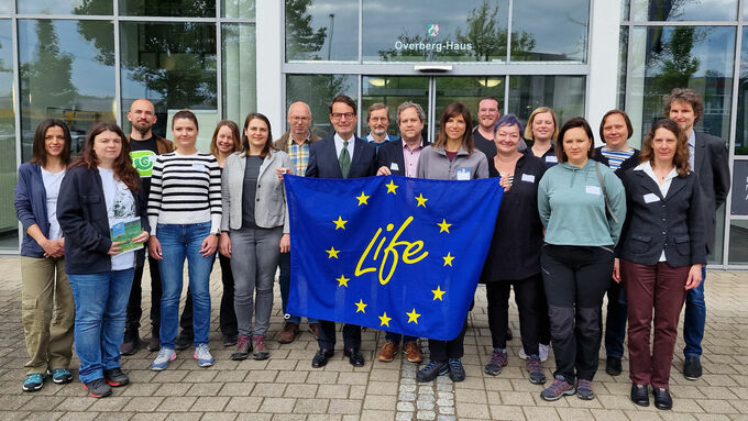 Group photo on arrival at the district government of Münster: District President Andreas Bothe and LIFE IP Project Manager Sebastian Schmidt hold the LIFE flag together with Karla Fabrio Čubrić, Head of Department for Protected Area Management at the